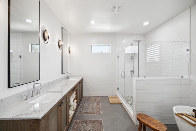 4731 Park Dr, Houston, TX 77023 - bathroom featuring a shower stall, double vanity, a freestanding tub, tile patterned floors, and recessed lighting