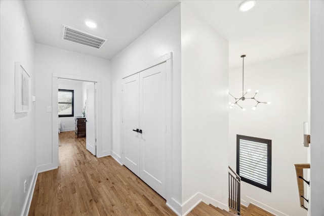 4731 Park Dr, Houston, TX 77023 - hall with a chandelier, light wood-style flooring, baseboards, an upstairs landing, and recessed lighting