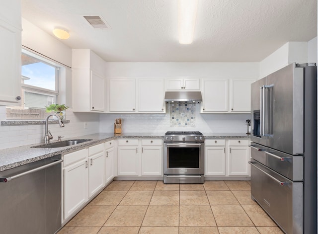 12007 Bach Orchard Trl, Houston, TX 77038 - kitchen featuring stainless steel appliances, a sink, under cabinet range hood, white cabinetry, and backsplash