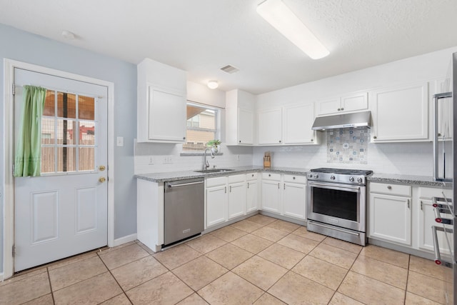 12007 Bach Orchard Trl, Houston, TX 77038 - kitchen with appliances with stainless steel finishes, under cabinet range hood, decorative backsplash, white cabinetry, and light tile patterned floors