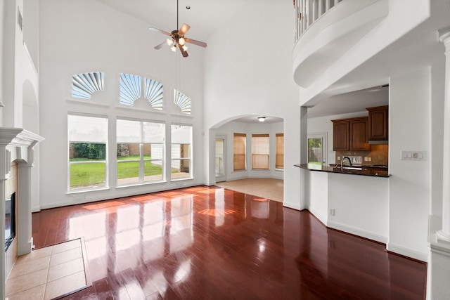 13202 Brushy Knoll Ln, Sugar Land, TX 77498 - unfurnished living room with light wood-style floors, ceiling fan, plenty of natural light, a sink, and a towering ceiling