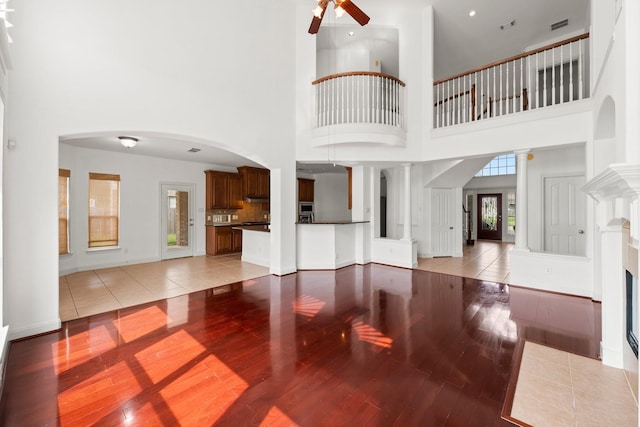 13202 Brushy Knoll Ln, Sugar Land, TX 77498 - unfurnished living room with a ceiling fan, light wood-type flooring, a towering ceiling, and baseboards