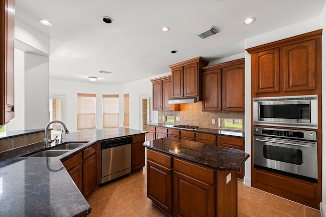 13202 Brushy Knoll Ln, Sugar Land, TX 77498 - kitchen with stainless steel appliances, a sink, light tile patterned floors, dark stone counters, and recessed lighting