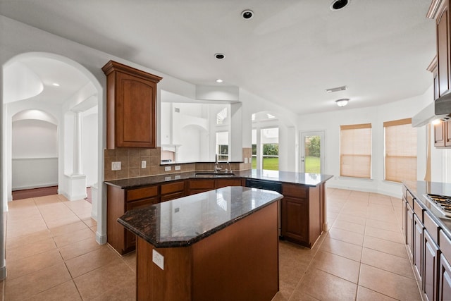 13202 Brushy Knoll Ln, Sugar Land, TX 77498 - kitchen featuring a center island, a sink, arched walkways, decorative backsplash, and recessed lighting
