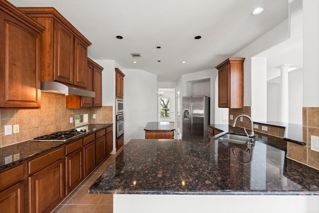 13202 Brushy Knoll Ln, Sugar Land, TX 77498 - kitchen featuring stainless steel appliances, a sink, a center island, under cabinet range hood, and dark stone counters