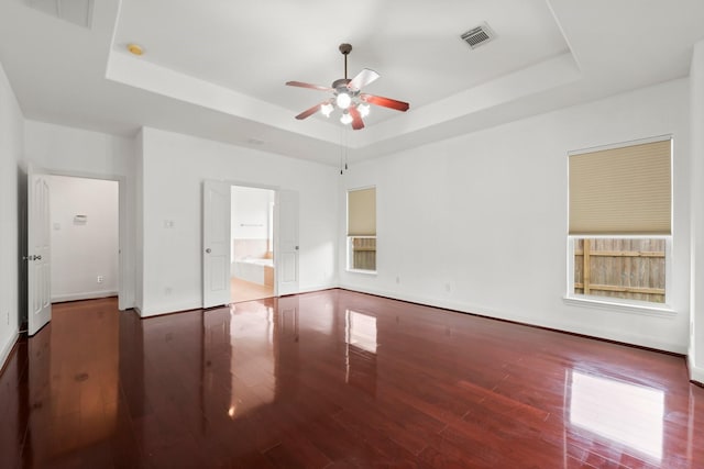 13202 Brushy Knoll Ln, Sugar Land, TX 77498 - unfurnished bedroom with a tray ceiling, wood finished floors, and baseboards