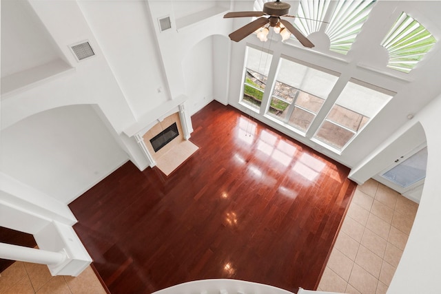 13202 Brushy Knoll Ln, Sugar Land, TX 77498 - unfurnished living room with a towering ceiling, a tile fireplace, a ceiling fan, and tile patterned floors