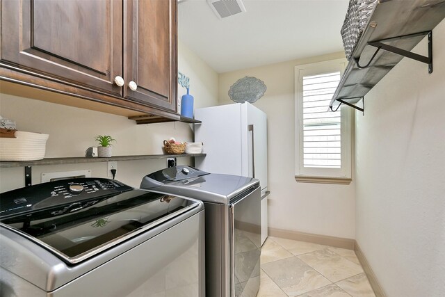 1530 Richland Hollow Ln, Friendswood, TX 77546 - laundry room featuring washing machine and clothes dryer, cabinet space, baseboards, and light tile patterned flooring