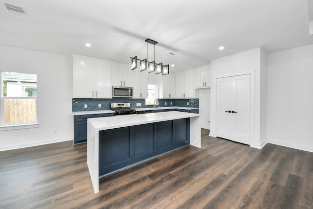 7440 Avenue E Ave E, Beasley, TX 77417 - kitchen with stainless steel microwave, electric range, healthy amount of natural light, white cabinets, and recessed lighting