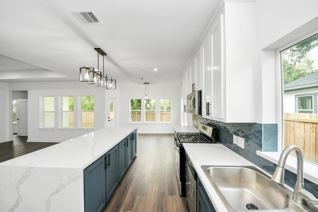 7440 Avenue E Ave E, Beasley, TX 77417 - kitchen featuring a sink, appliances with stainless steel finishes, white cabinetry, dark wood-style floors, and a center island