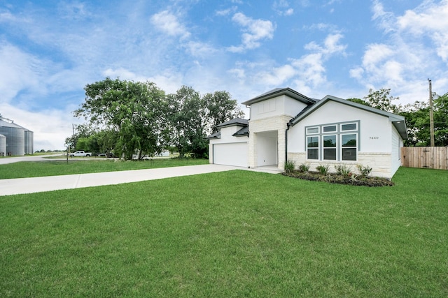 7440 Avenue E Ave E, Beasley, TX 77417 - view of front of home featuring concrete driveway, stone siding, an attached garage, and stucco siding