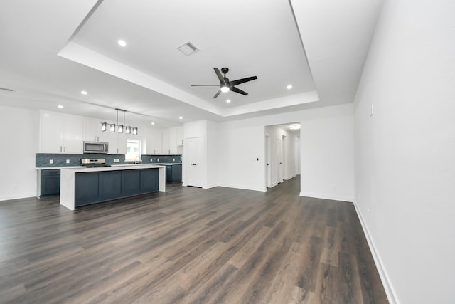 7440 Avenue E Ave E, Beasley, TX 77417 - unfurnished living room with a tray ceiling, recessed lighting, ceiling fan, baseboards, and dark wood-type flooring