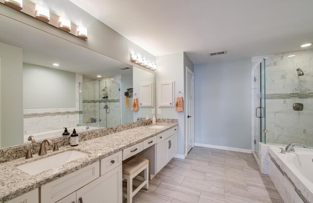 4303 Jonathan St, Bellaire, TX 77401 - full bathroom with double vanity, a bath, a stall shower, recessed lighting, and baseboards