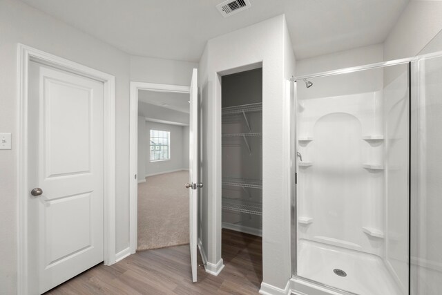 6430 Winter Elm St, Houston, TX 77048 - bathroom with a stall shower, wood finished floors, and a walk in closet