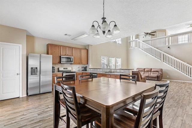 703 Windlass Way, Crosby, TX 77532 - dining space featuring stairs, a chandelier, light wood finished floors, and ceiling fan