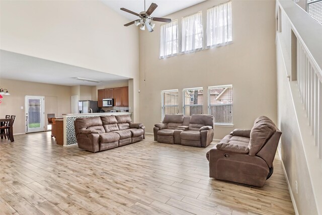 703 Windlass Way, Crosby, TX 77532 - living area with light wood finished floors, baseboards, a high ceiling, and plenty of natural light