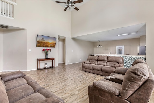 703 Windlass Way, Crosby, TX 77532 - living area with wood finished floors, ceiling fan, a towering ceiling, and baseboards