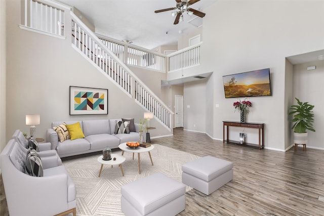 703 Windlass Way, Crosby, TX 77532 - living area featuring stairs, ceiling fan, wood finished floors, a towering ceiling, and baseboards
