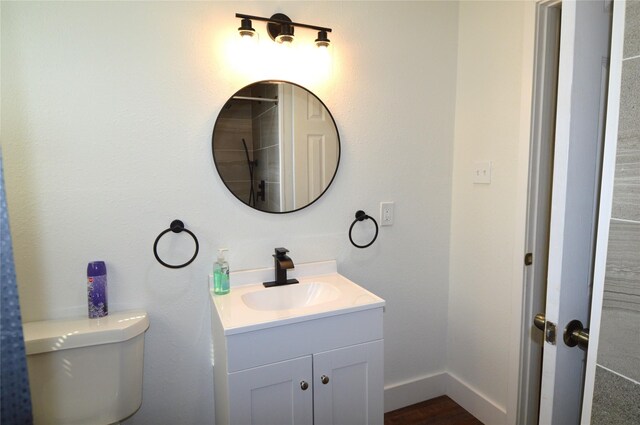 405 W Jack St, Baytown, TX 77520 - bathroom with vanity, toilet, wood finished floors, and baseboards