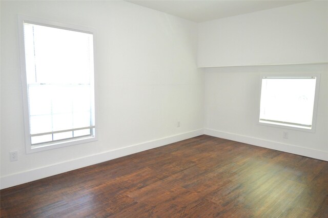 405 W Jack St, Baytown, TX 77520 - empty room with healthy amount of natural light, baseboards, and dark wood finished floors