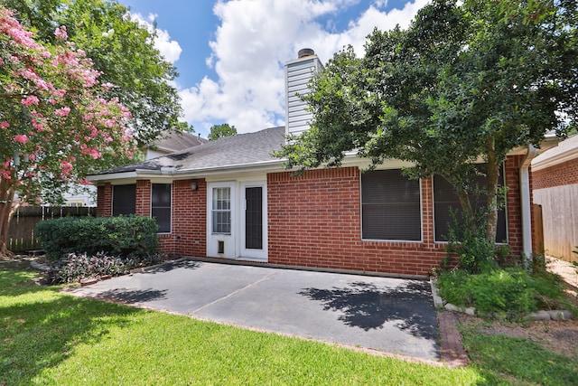 8006 Virginia Water Ln, Houston, TX 77095 - rear view of house with brick siding, a patio, and a chimney