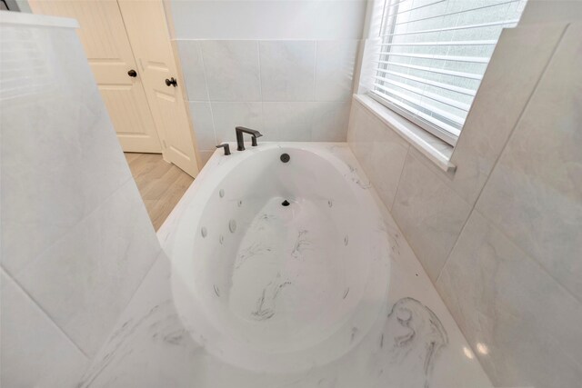 234 Feldspar Ln, Huntsville, TX 77340 - bathroom with a jetted tub and tile walls