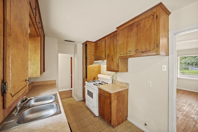 5814 Darnell St, Houston, TX 77074 - kitchen featuring gas range gas stove, a sink, light countertops, and baseboards