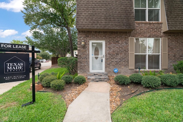 820 Threadneedle St Unit 248, Houston, TX 77079 - view of exterior entry with a shingled roof, brick siding, and mansard roof