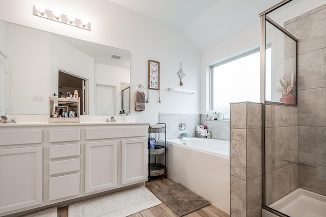 1004 Breech Dr, Crosby, TX 77532 - full bath featuring wood finished floors, a garden tub, a shower stall, double vanity, and lofted ceiling