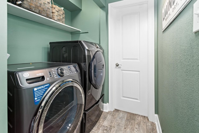 12802 Bergeron Dr, Hamshire, TX 77622 - laundry room featuring washer and clothes dryer, wood finished floors, and baseboards
