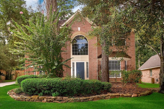 23 Shellbark, The Woodlands, TX 77382 - view of front facade with brick siding and a front lawn