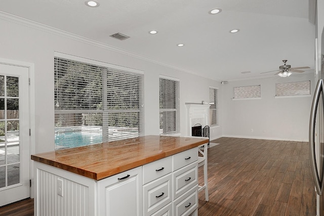 23 Shellbark, The Woodlands, TX 77382 - kitchen with butcher block countertops, ornamental molding, dark wood-style flooring, recessed lighting, and open floor plan