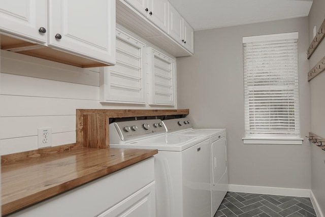 23 Shellbark, The Woodlands, TX 77382 - laundry room featuring separate washer and dryer, cabinet space, baseboards, and dark tile patterned flooring