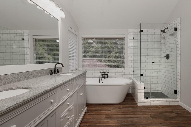 23 Shellbark, The Woodlands, TX 77382 - bathroom featuring vaulted ceiling, a stall shower, a soaking tub, double vanity, and wood finished floors