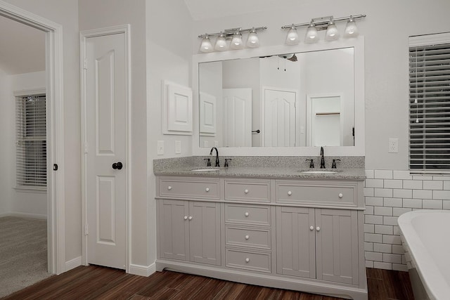 23 Shellbark, The Woodlands, TX 77382 - full bathroom featuring a freestanding bath, double vanity, wood finished floors, and tile walls
