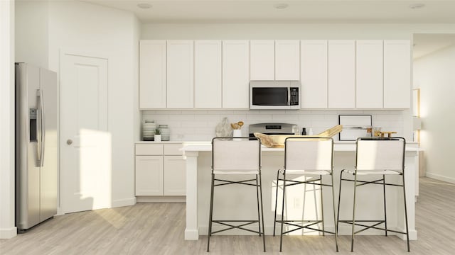 3068 Ruby Ridge Dr, Katy, TX 77493 - kitchen with stainless steel appliances, light wood-style floors, decorative backsplash, light countertops, and a center island with sink