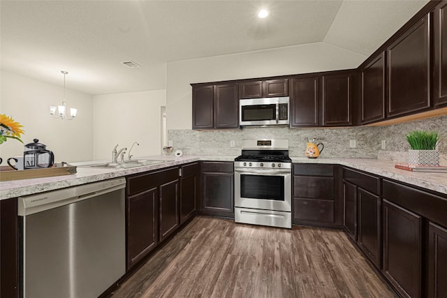 20910 Corisande St, Katy, TX 77449 - kitchen featuring appliances with stainless steel finishes, dark wood-type flooring, dark brown cabinetry, and a chandelier