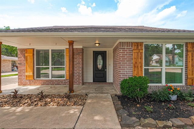 6526 Mert St, Katy, TX 77493 - view of exterior entry with brick siding, roof with shingles, and covered porch