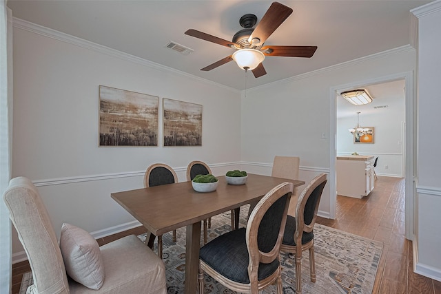 6526 Mert St, Katy, TX 77493 - dining area with wood finished floors, ornamental molding, ceiling fan, a chandelier, and baseboards