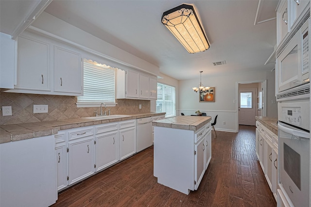 6526 Mert St, Katy, TX 77493 - kitchen featuring a sink, white appliances, a center island, white cabinetry, and dark wood finished floors