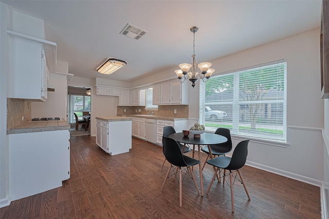 6526 Mert St, Katy, TX 77493 - dining area featuring a chandelier, dark wood-type flooring, and baseboards