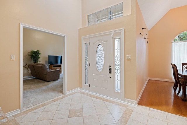 12910 Lake Mist Dr, Cypress, TX 77429 - entryway featuring light tile patterned floors, a high ceiling, and baseboards