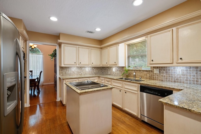 12910 Lake Mist Dr, Cypress, TX 77429 - kitchen featuring stainless steel appliances, a sink, cream cabinetry, tasteful backsplash, and recessed lighting