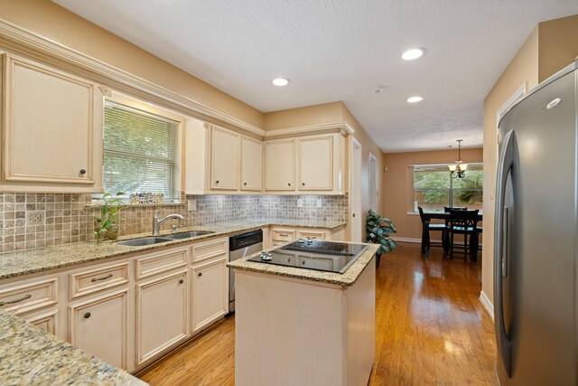 12910 Lake Mist Dr, Cypress, TX 77429 - kitchen with appliances with stainless steel finishes, a sink, cream cabinetry, backsplash, and light wood-style floors