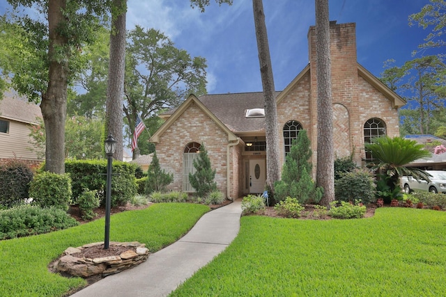 12910 Lake Mist Dr, Cypress, TX 77429 - view of front of house with brick siding, a chimney, a front lawn, and roof with shingles