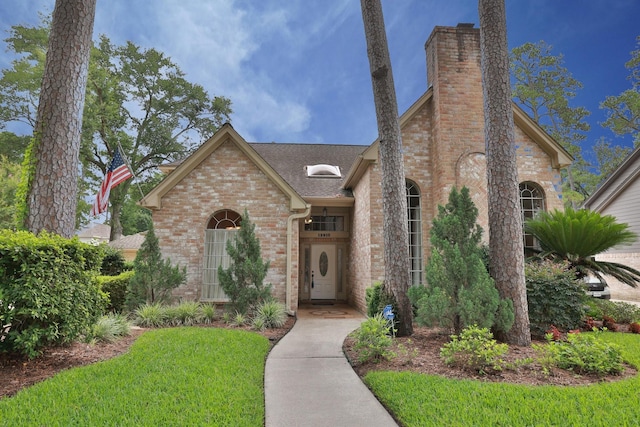 12910 Lake Mist Dr, Cypress, TX 77429 - view of front facade with brick siding, a chimney, a shingled roof, and a front yard