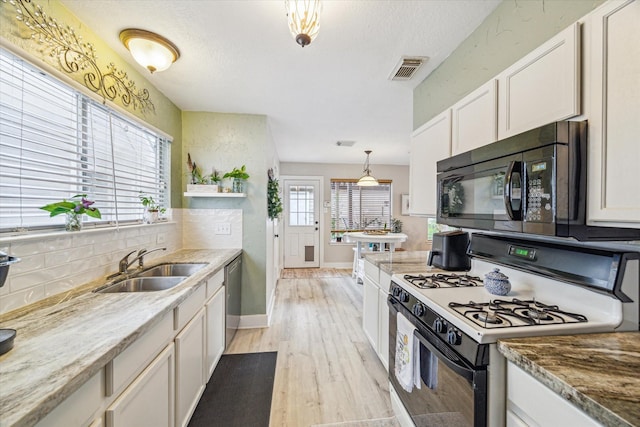 18614 Atasca Oaks Dr, Humble, TX 77346 - kitchen featuring gas range oven, black microwave, light wood finished floors, decorative backsplash, and a sink