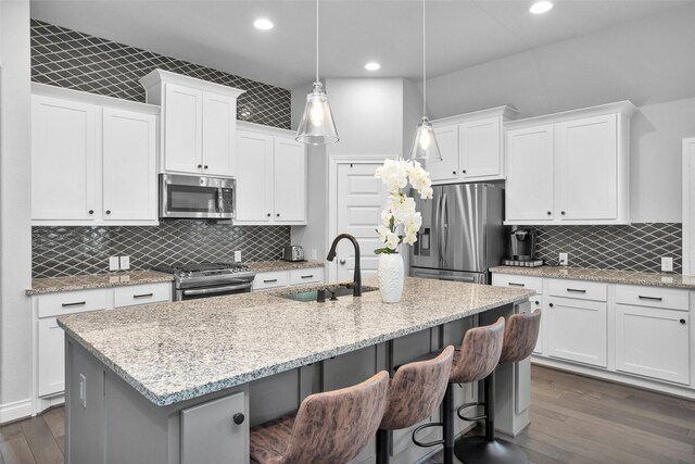 20423 Noble Arabian Dr, Tomball, TX 77377 - kitchen with appliances with stainless steel finishes, dark wood finished floors, recessed lighting, white cabinetry, and decorative backsplash