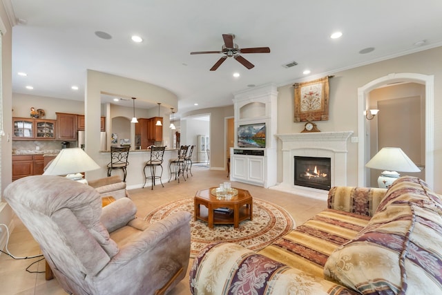 25514 Long Iron Ct, Spring, TX 77389 - living area with a ceiling fan, light tile patterned floors, recessed lighting, arched walkways, and a glass covered fireplace