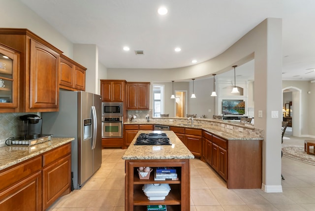 25514 Long Iron Ct, Spring, TX 77389 - kitchen with appliances with stainless steel finishes, open shelves, brown cabinets, arched walkways, and recessed lighting